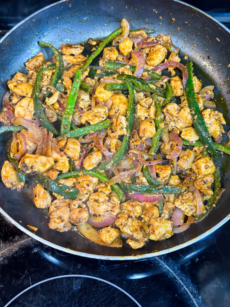 Chicken, onions, hot green pepper in pan